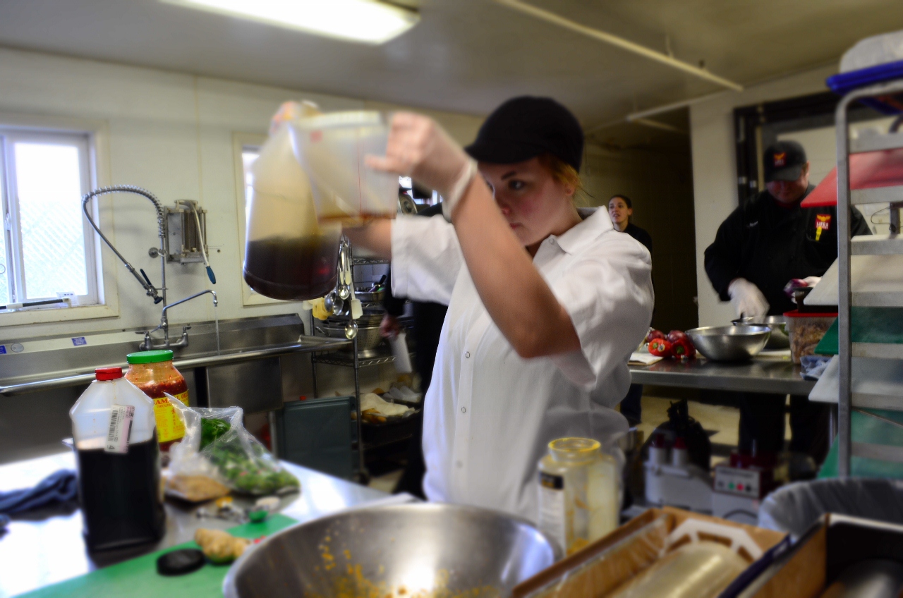 A student at Life's Kitchen measures ingredients as she competes in an appetizer contest.